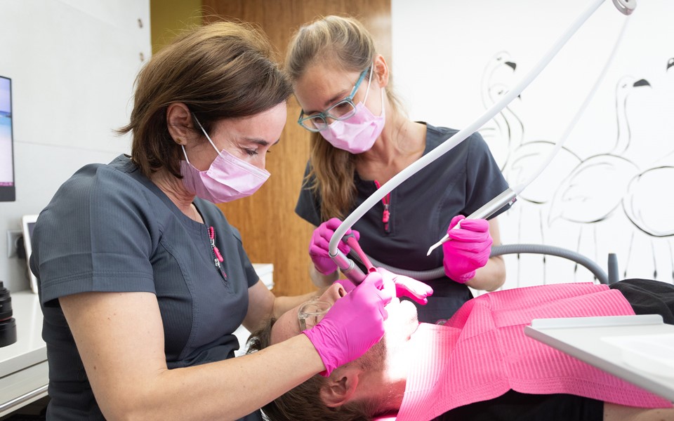 Lek. dent. Joanna Kisiel i lek. dent. Joanna Brzóska pracujące z pacjentem na unicie XO FLEX
