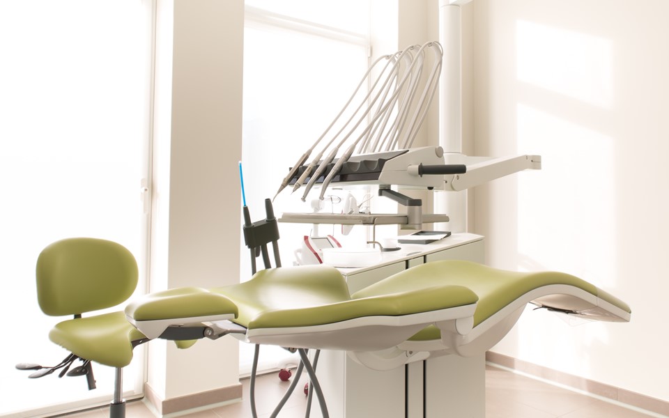 Unit stomatologiczny XO 4 z oliwkową tapicerką i rozłożonym fotelem pacjenta